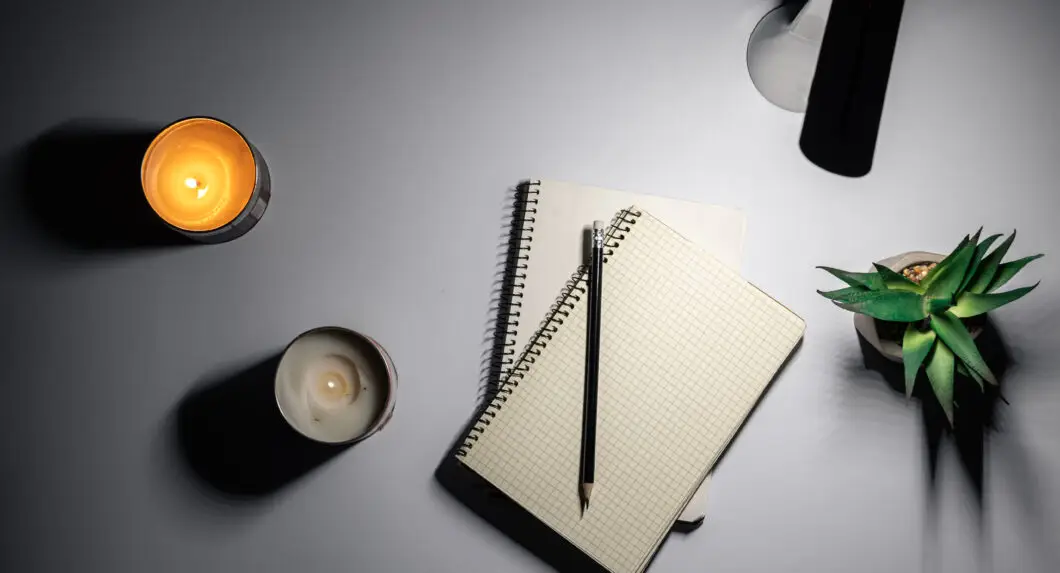 Carnet ouvert avec une liste manuscrite sous une lampe de bureau, le soir